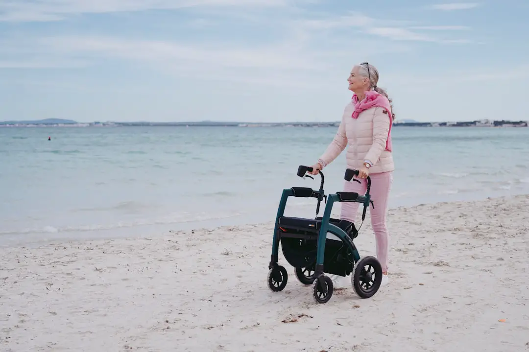 a woman standing on a beach next to a stroller