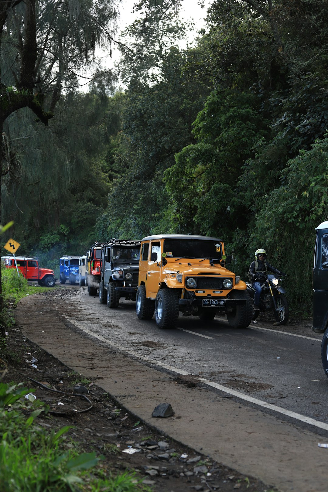 a person on a motorcycle next to a yellow truck