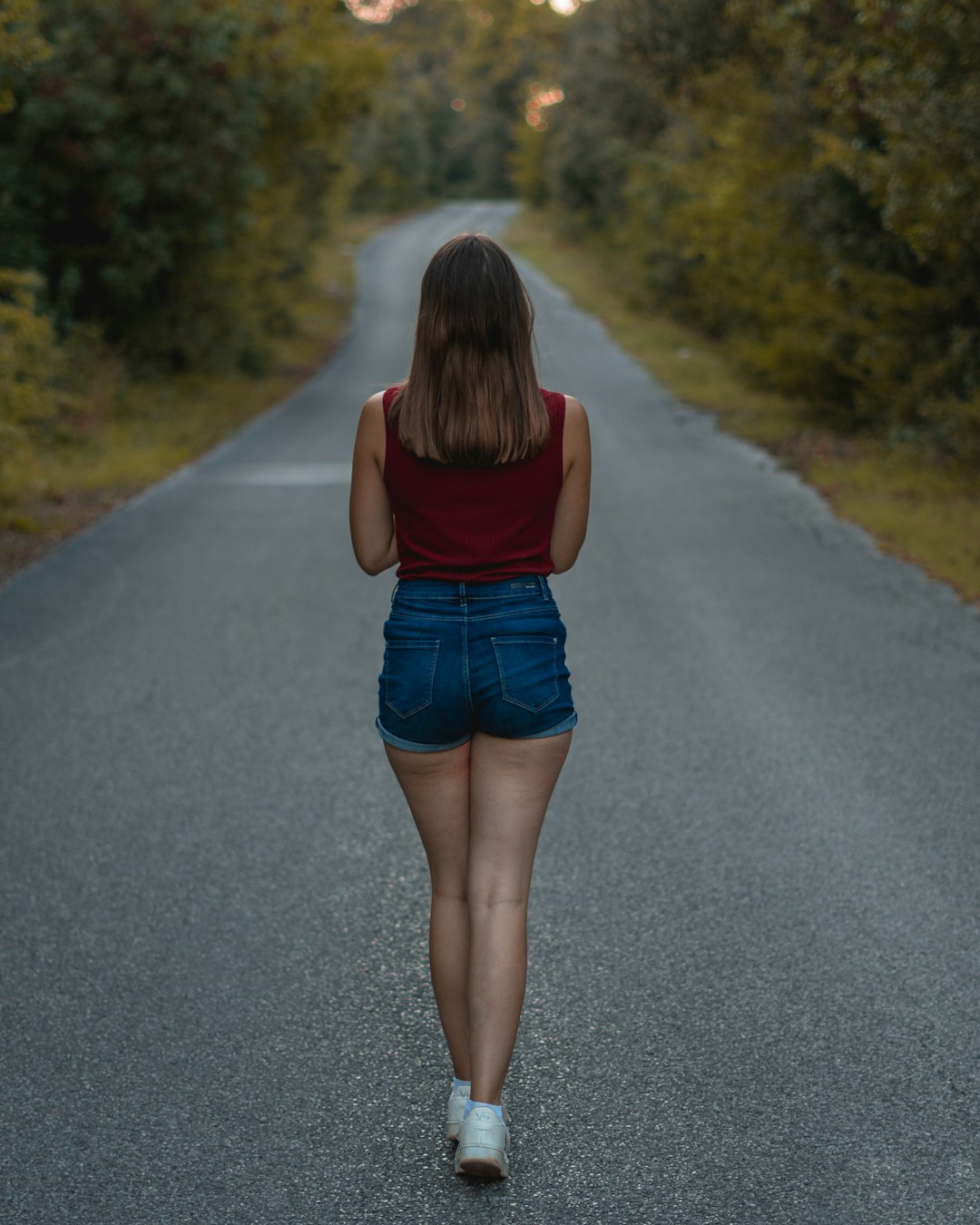 a woman walking down the middle of a road