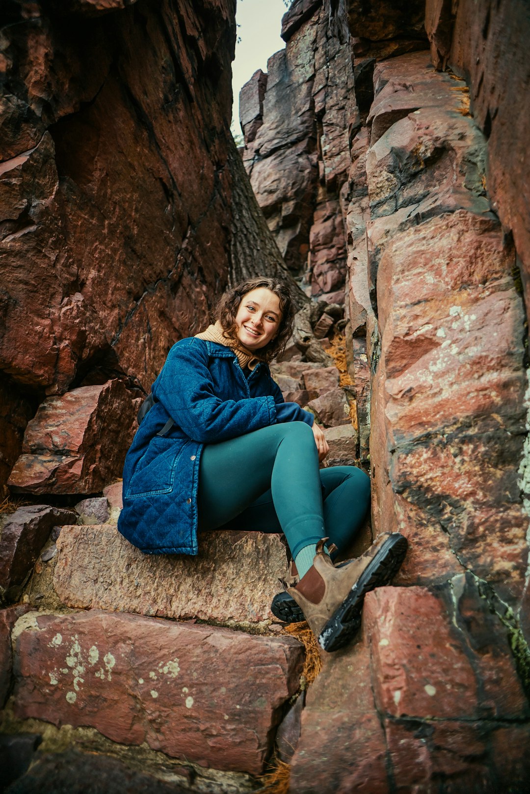 a woman sitting on a rock in a canyon