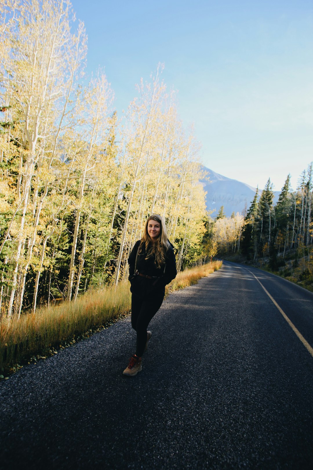 woman in black jacket standing on road during daytime