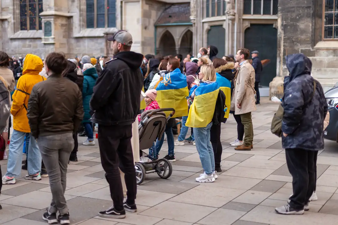 a crowd of people standing on a sidewalk next to a building