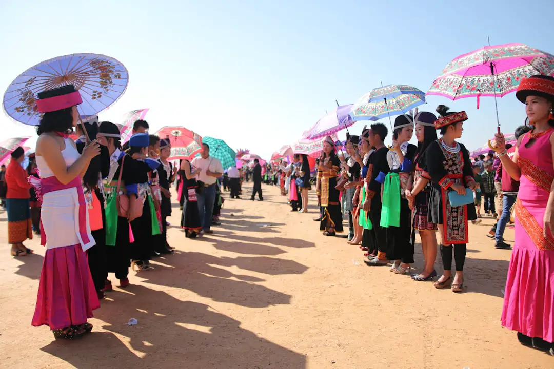 a large group of people with umbrellas on a dirt field