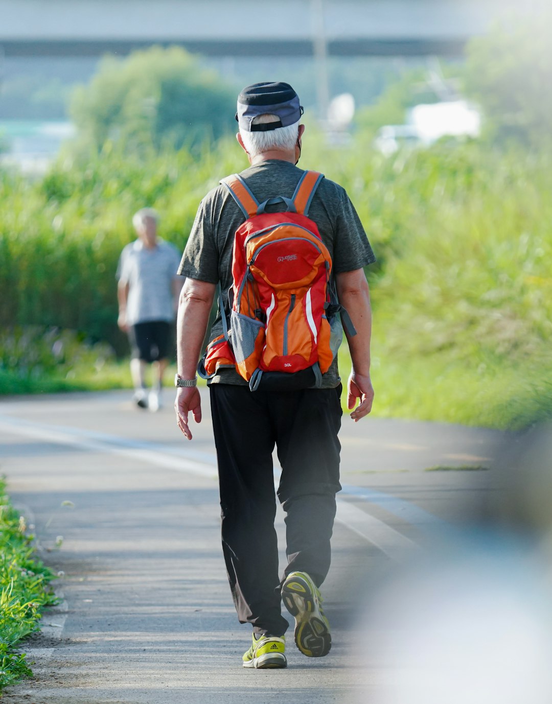 a man walking down a road with a backpack on his back