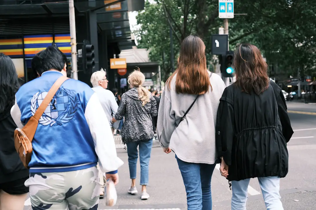 A group of people walking across a street
